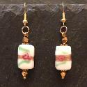 Gold earrings with rectangular bead embellished with rose design.
