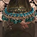 Underwater charm bracelet with turquoise glass beads on a turquoise chain.