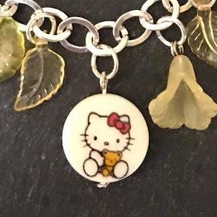 Close up view of kitty shell coin on the bracelet.